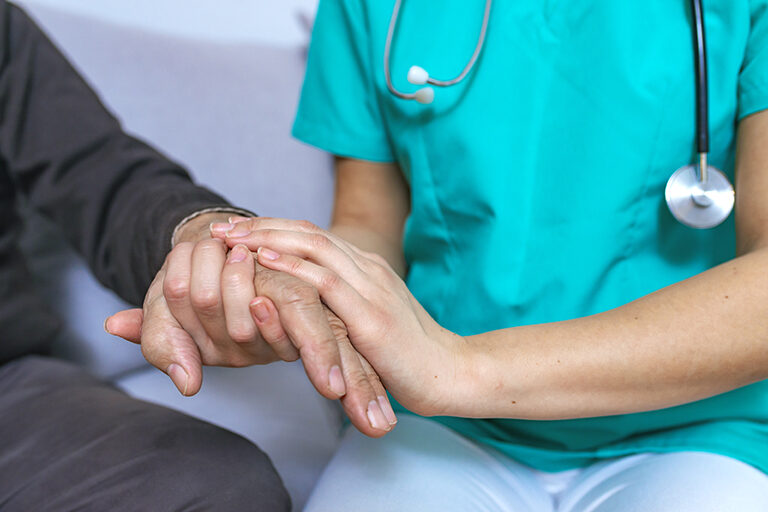 A clinician holding a patient's hand