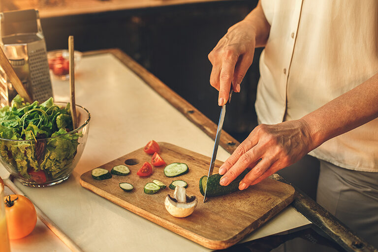 How Nutrition Can Help You Better Manage a Chronic Illness Woman cooking at home in the kitchen
