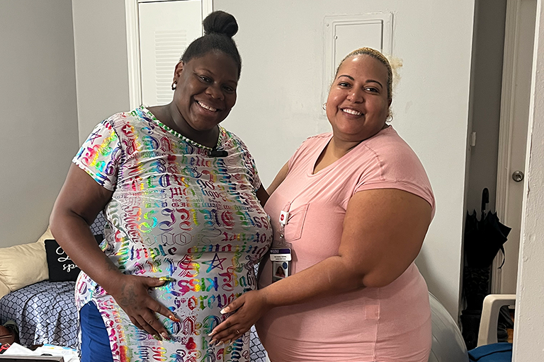CCA Tyiesha and her CCA doula Ruth posing for a photo in a living room