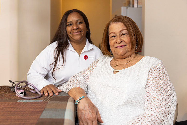 Senior woman sitting with her CCA care partner in her home