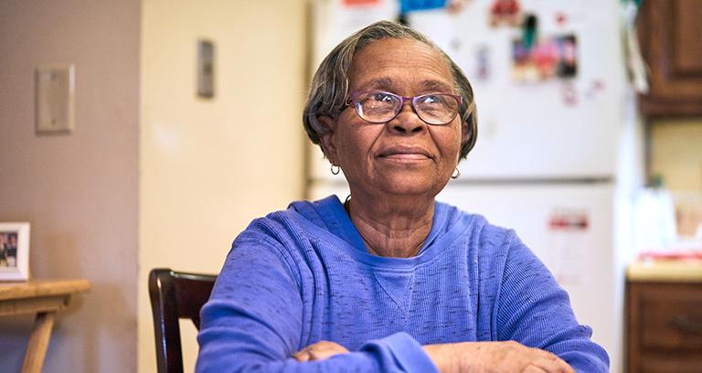 Senior woman seated at table in her kitchen