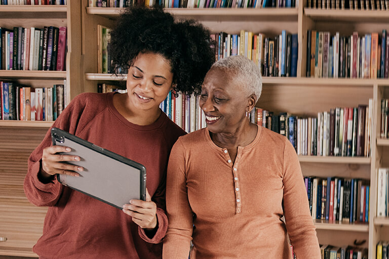 woman and daughter looking at tablet