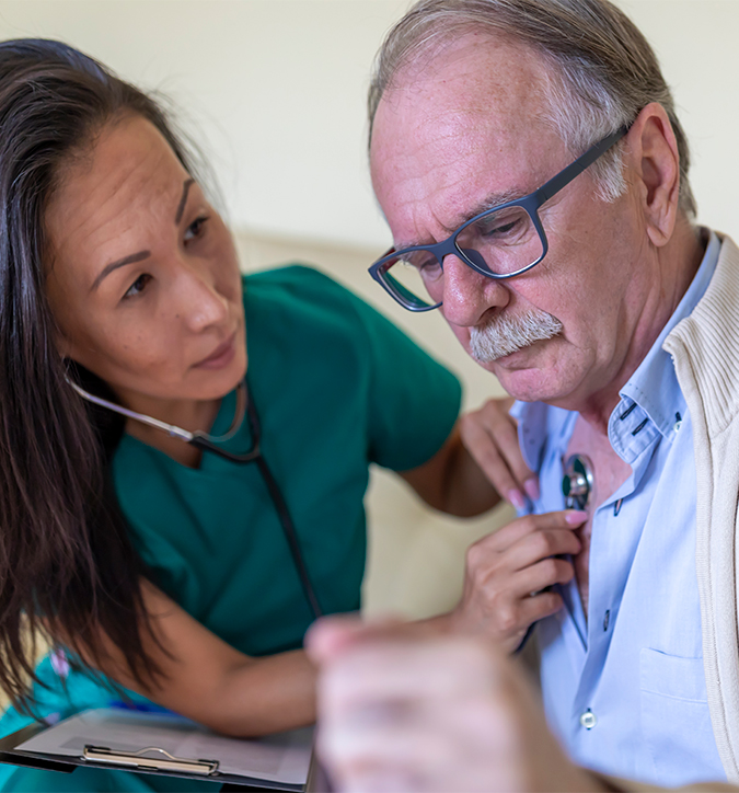 Female paramedic focused on senior patient in patient's living room