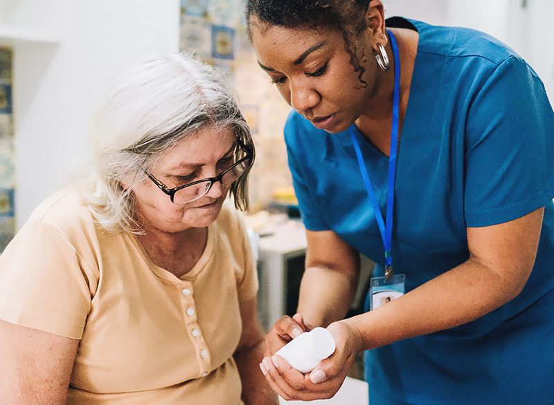 Female paramedic focused on senior patient in patient's living room