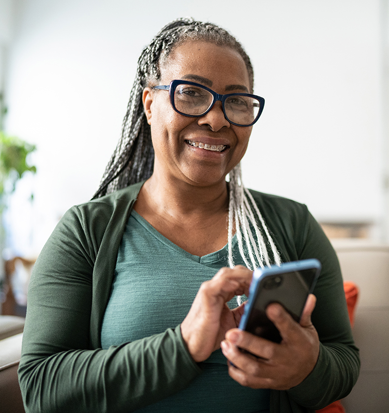 women smiling with smartphone in hand