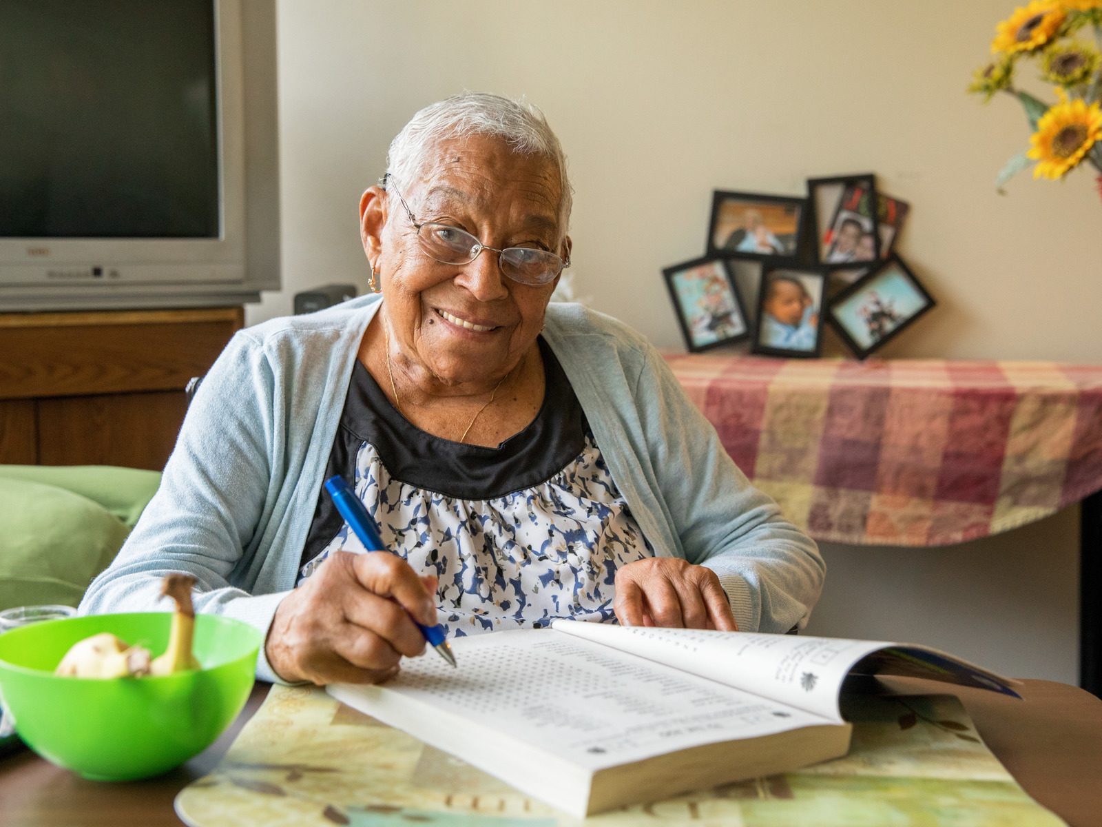 Senior woman working on crossword puzzle in her living room