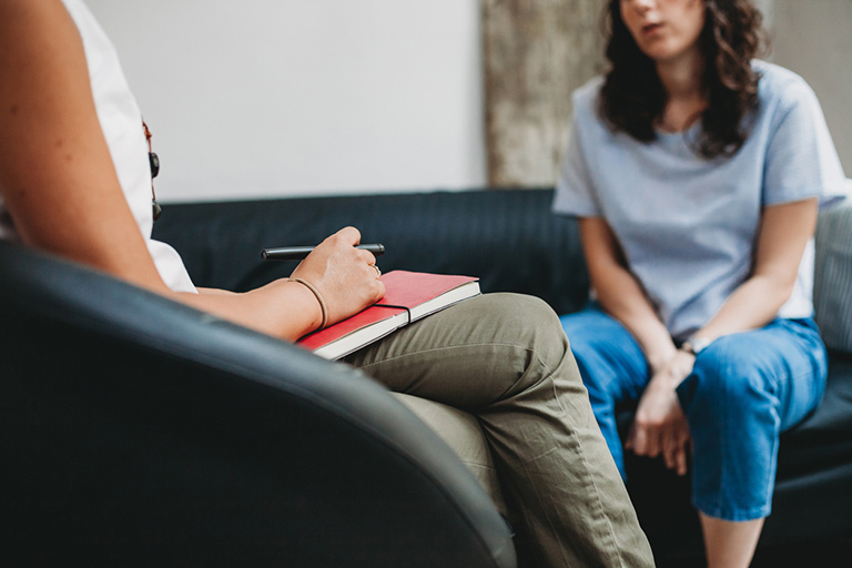 Closeup of two women seated facing each other in counseling session