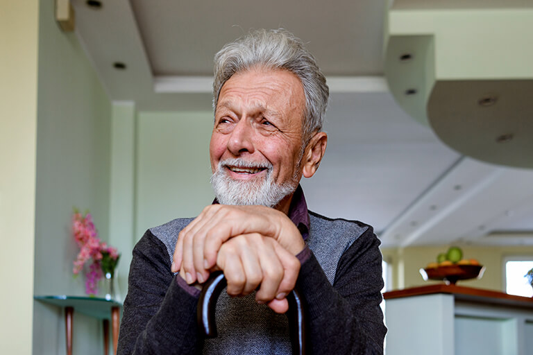 Senior man smiling holding cane