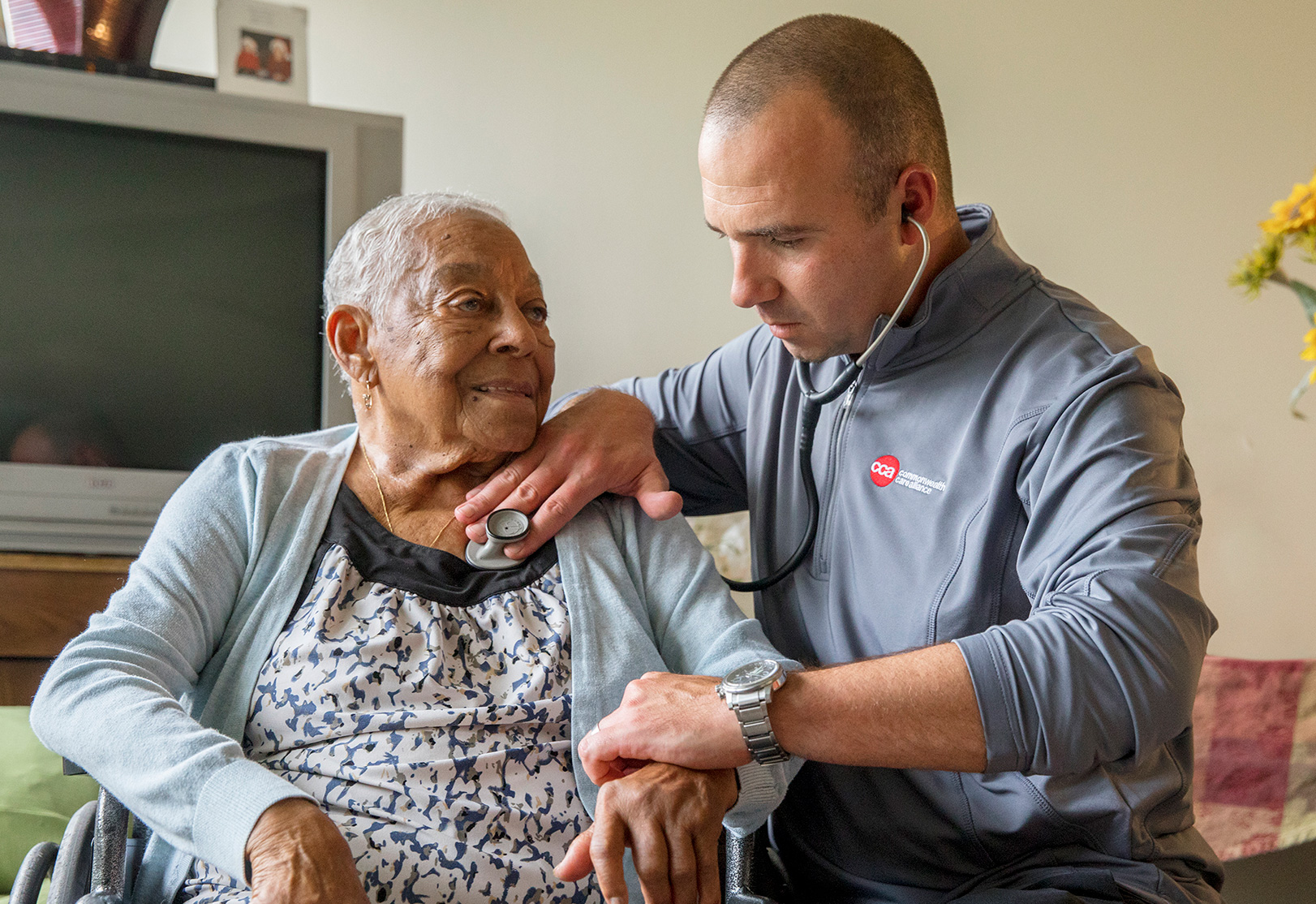 Senior woman receiving care from a man with a stethoscope