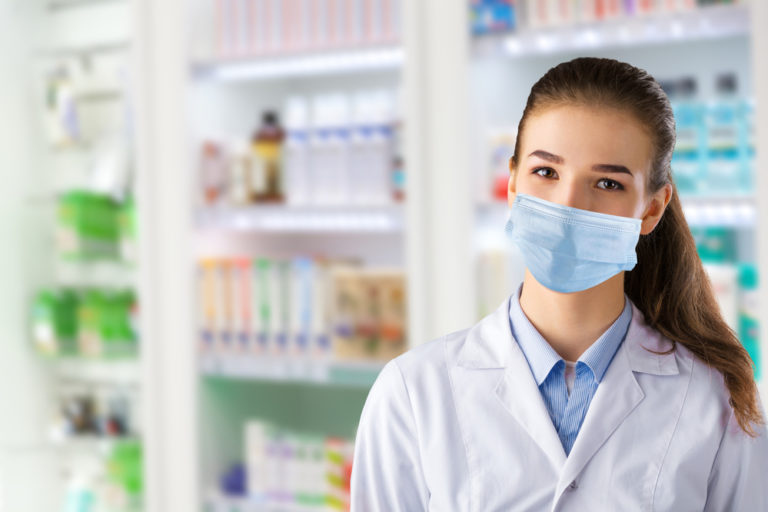 Commonwealth Care Alliance® and Community Pharmacy Enhanced Services Network Announce Innovative Accountable Pharmacy Partnership in Massachusetts Young woman pharmacist wearing mask inside pharmacy