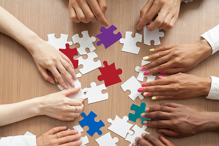 A diverse group of people putting together a puzzle