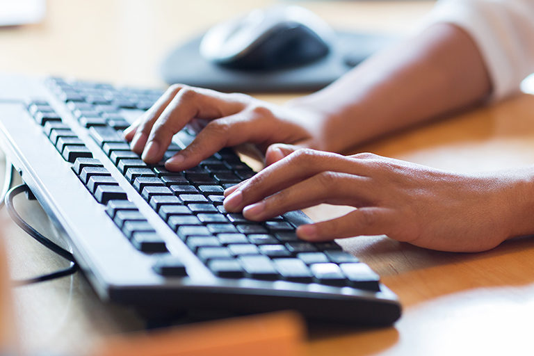 Close up of African American female hands typing on keyboard