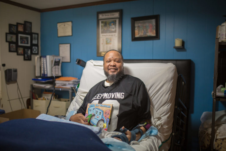 Rey's story CCA One Care member in bed with book