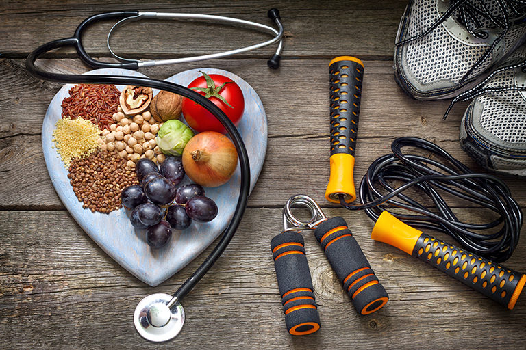 Image of a plate with healthy food options surrounded by sneakers and exercise equipment