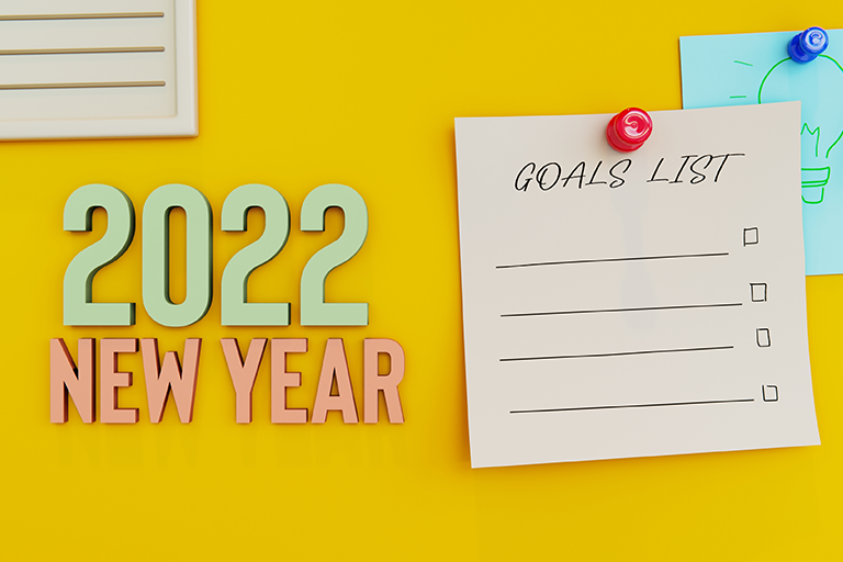 An image with the writing 2022 New Year and an image of a notepad to write down New Year's resolutions