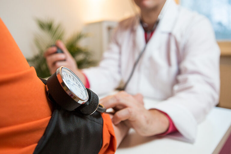 A doctor taking a patient's blood pressure