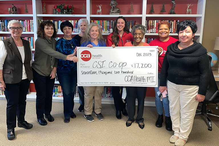 Image of a CCA employee presenting a donation check to the staff at CSI