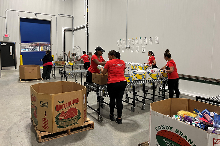 CCA employees packing food while volunteering at a local food bank