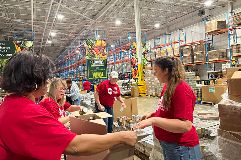 CCA Health MI employees volunteering at Gleaners Food Bank, putting food inside of boxes