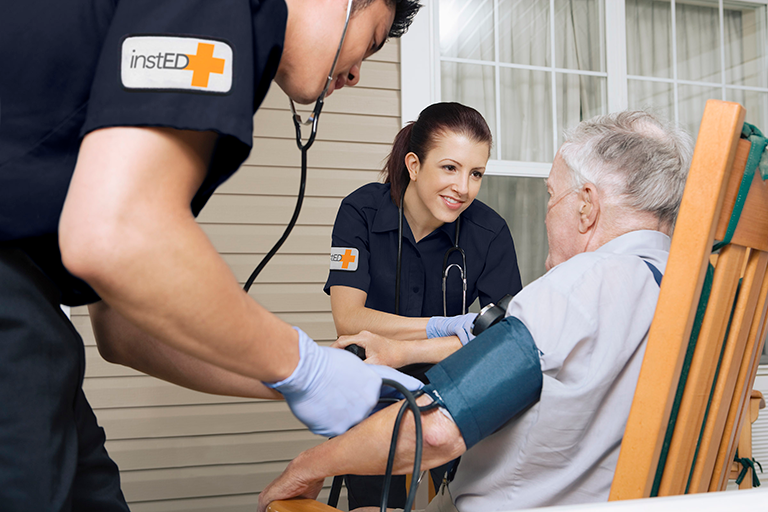 Paramedics helping an older adult at home