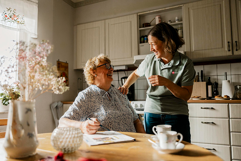 Living Well At Home: Fall 2025 CCA member sitting in her kitchen while talking to a CCA care team member